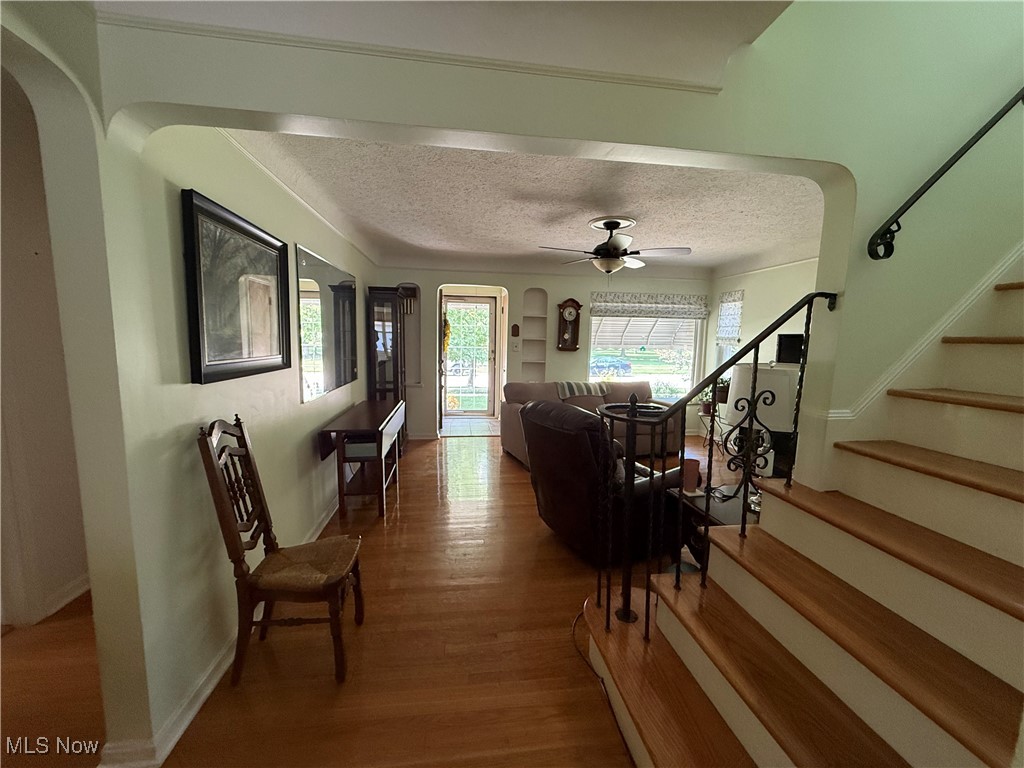 6289 Manchester Road Parma, OH 44129 - Photo 20 of 46 View from Four Seasons Room to Front Door with wood finished floors, a ceiling fan, arched walkways, and stairway