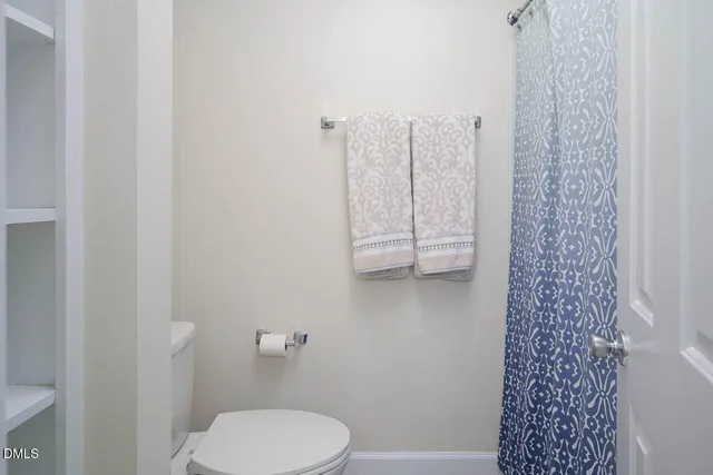 a white toilet sitting next to a shower curtain