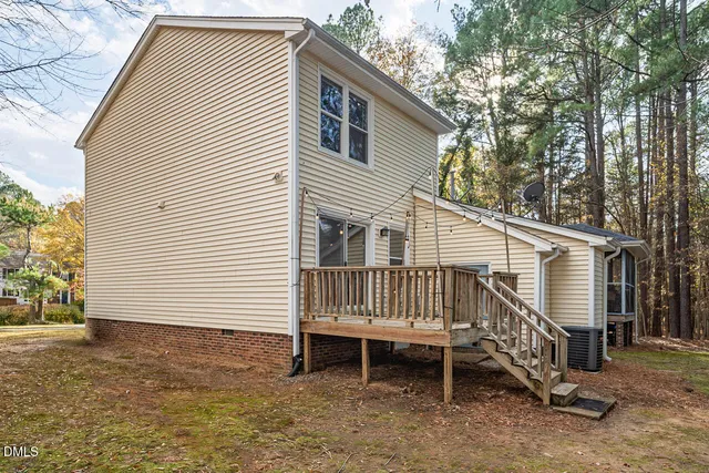 a view of a house with a yard chairs and wooden fence