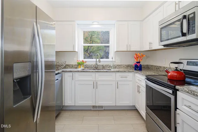 a kitchen with a sink window and cabinets