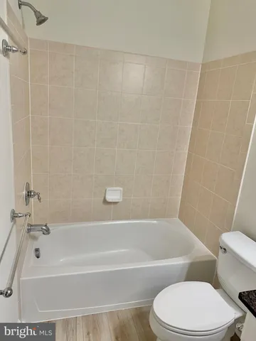 a kitchen with stainless steel appliances granite countertop a refrigerator stove and white cabinets