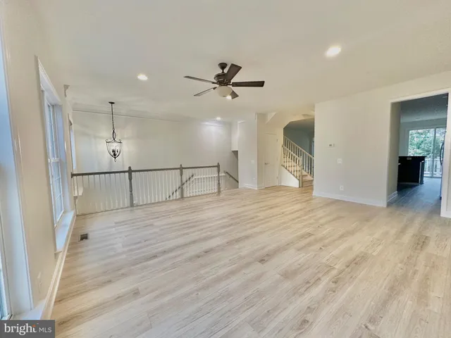 a view of staircase with wooden floor and white walls