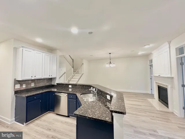 a kitchen with stainless steel appliances granite countertop a refrigerator a stove top oven a sink and dishwasher with wooden floor