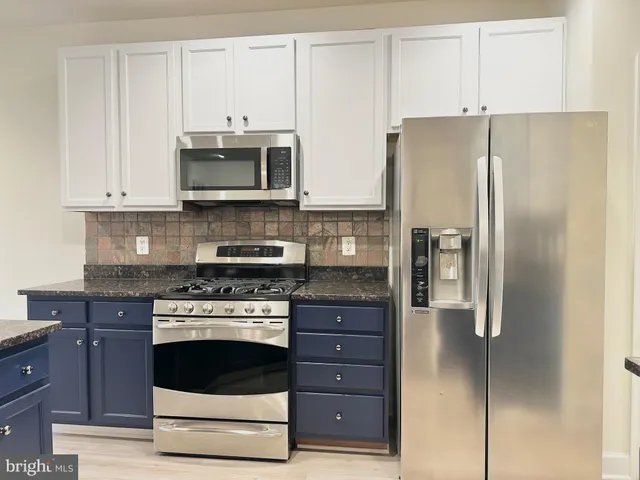 a kitchen with stainless steel appliances a refrigerator stove microwave and sink
