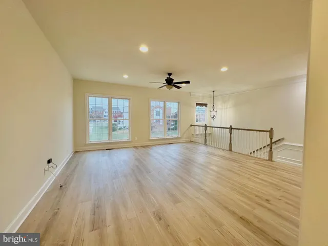 a view of a hallway with wooden floor and a bathroom