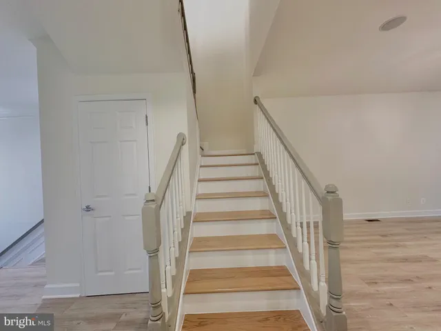 a view of empty room with wooden floor and ceiling fan