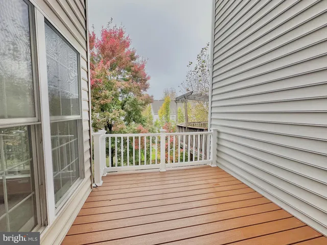 a view of a hallway with entryway wooden floor and windows