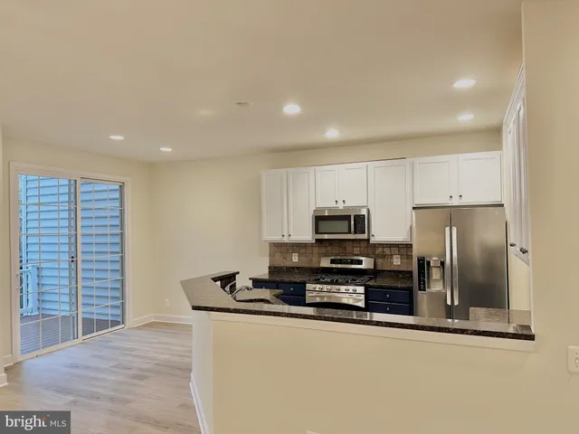 a kitchen with granite countertop a sink and a wooden floor