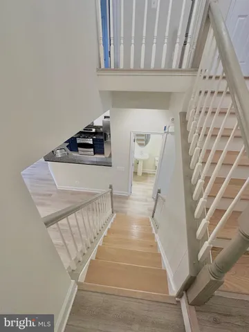 a view of a hallway with wooden floor and stairs