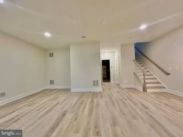 a view of a hallway with wooden floor and staircase