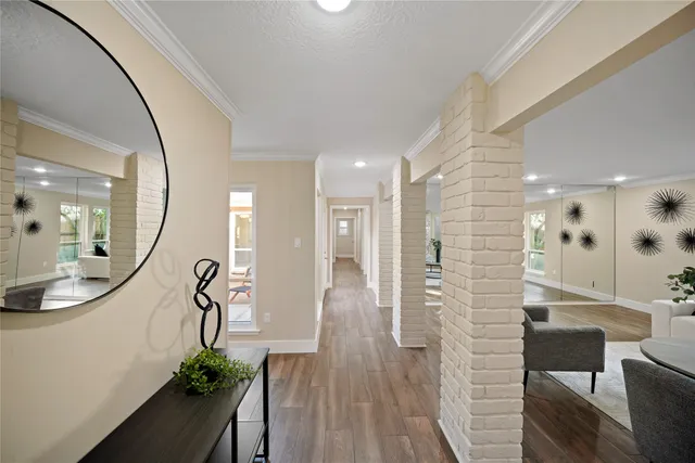 a view of a hallway with wooden floor windows and a livingroom