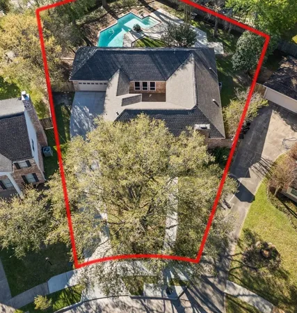 a front view of a house with a yard and a tree