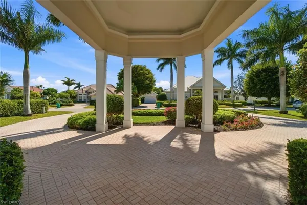 a view of a house with a yard and palm trees