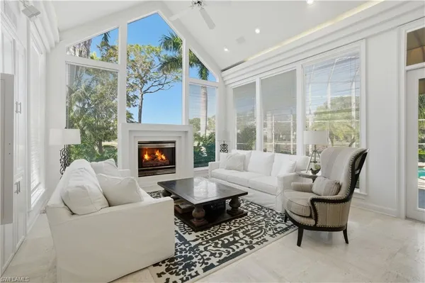 a living room with furniture large window and a fireplace