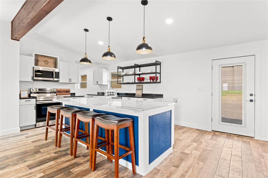 1265 North Houston Street Lorena, TX 76655 - Photo 5 of 29 a open kitchen with stainless steel appliances granite countertop a stove and a wooden floor