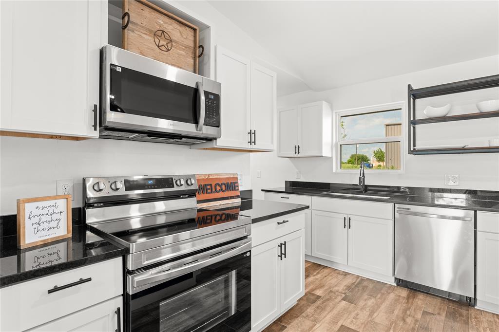 1265 North Houston Street Lorena, TX 76655 - Photo 8 of 29 a kitchen with stainless steel appliances a stove microwave and sink