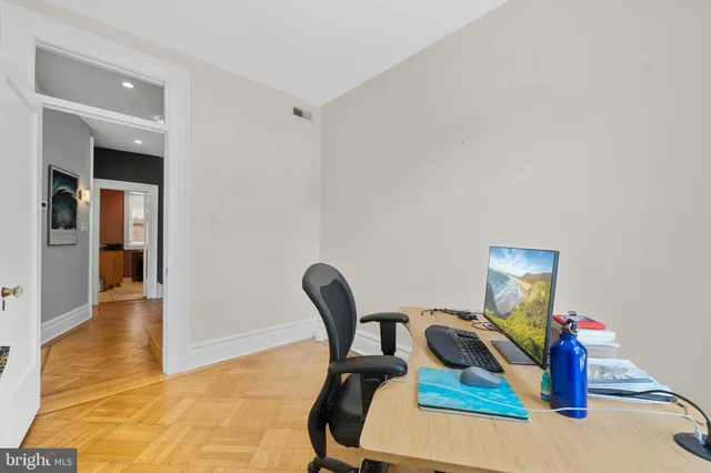 a view of a workspace with furniture and a window