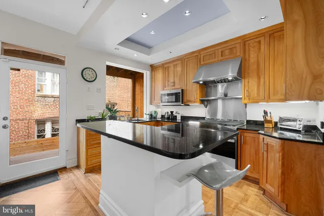 a kitchen with granite countertop a sink stove and refrigerator