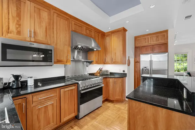 a kitchen with stainless steel appliances granite countertop a stove a sink dishwasher and a microwave oven with cabinets