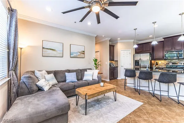 a living room with furniture kitchen view and a chandelier