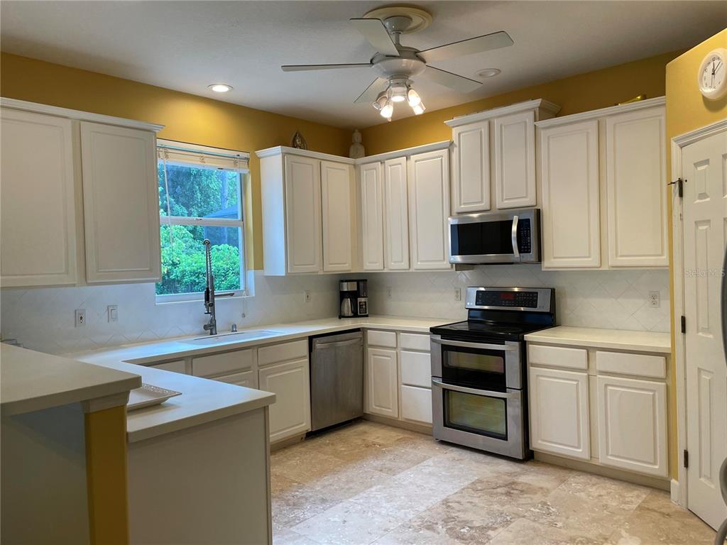 759 Fordingbridge Way Osprey, FL 34229 - Photo 34 of 51 a kitchen with stainless steel appliances a stove sink microwave refrigerator and cabinets