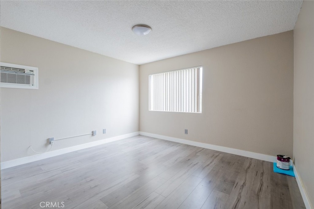 1341 North Keystone Street, Unit E Burbank, CA 91506 - Photo 12 of 16 an empty room with wooden floor and windows