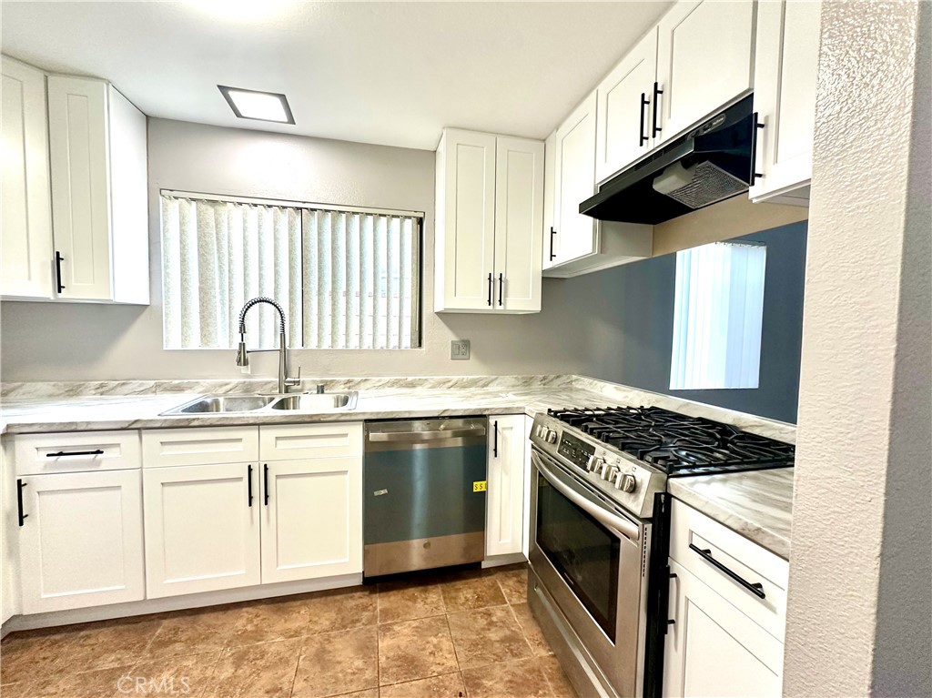 1341 North Keystone Street, Unit E Burbank, CA 91506 - Photo 3 of 16 a kitchen with granite countertop stainless steel appliances sink stove and cabinets