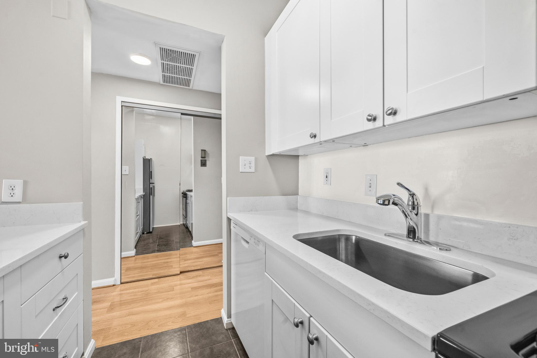 1851 Columbia Road Northwest, Unit 401 Washington, DC 20009 - Photo 11 of 27 a kitchen with white cabinets and a sink