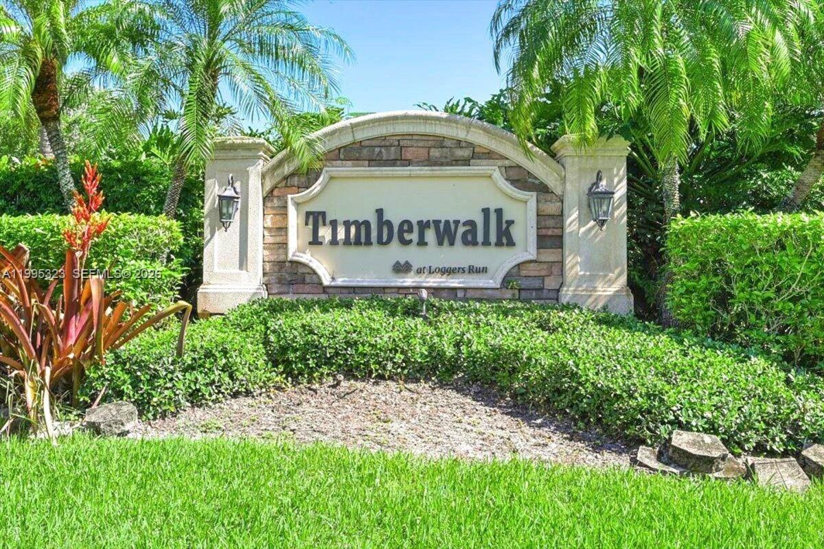 22278 Misty Woods Way, Unit 22278 Boca Raton, FL 33428 - Photo 16 of 20 a sign of golf club on a wall under a tree