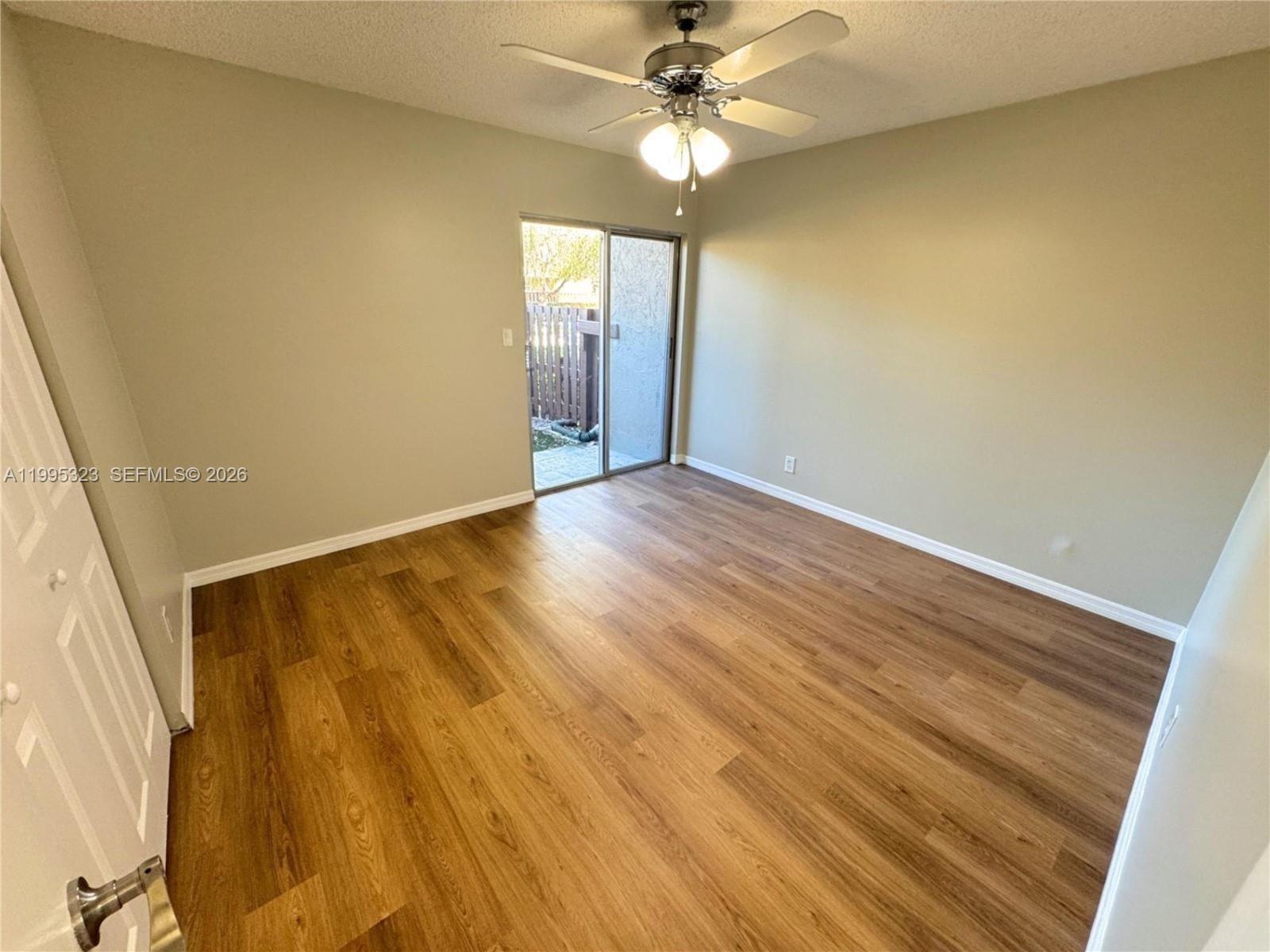22278 Misty Woods Way, Unit 22278 Boca Raton, FL 33428 - Photo 7 of 20 a view of an empty room with wooden floor and a window