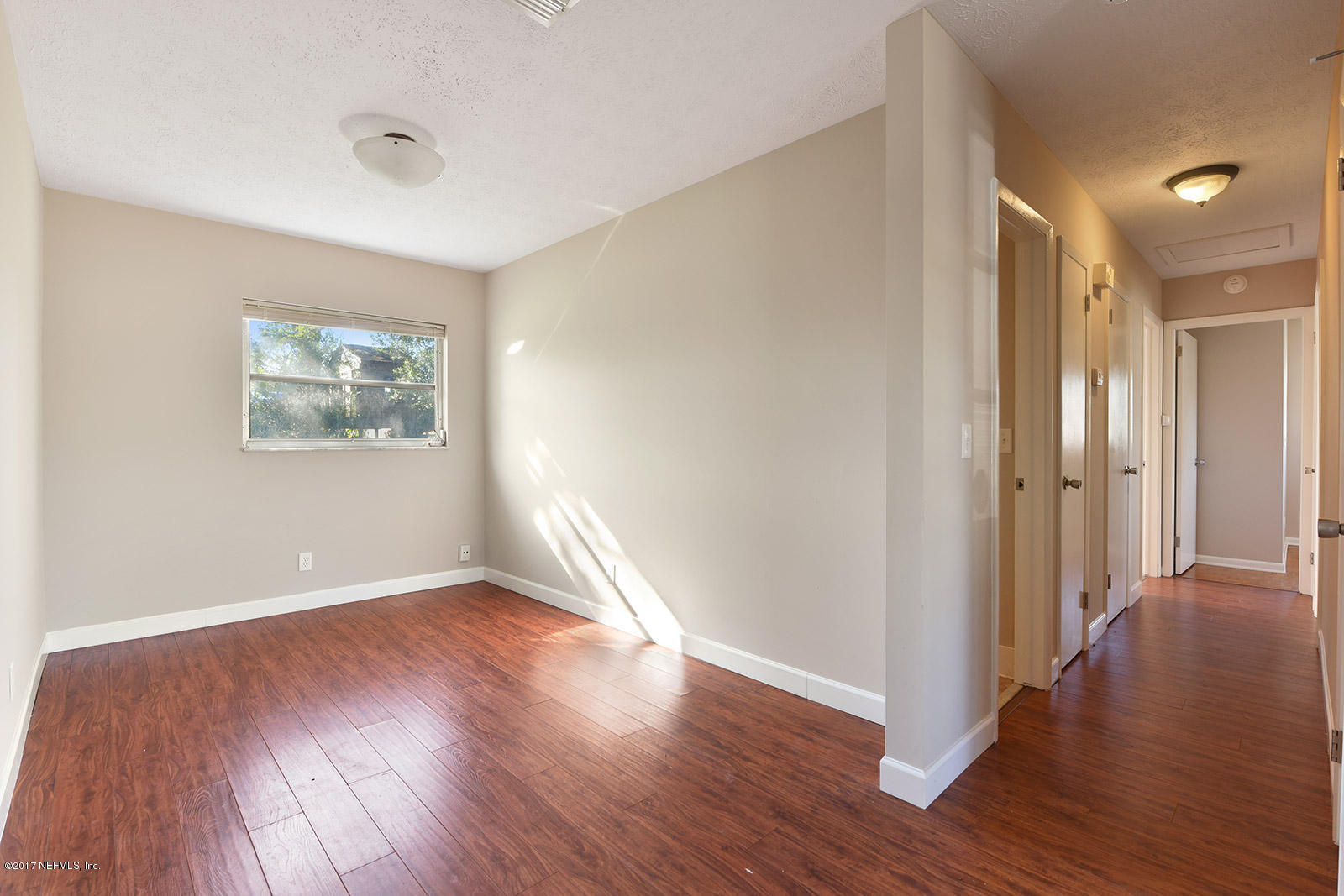 8182 Newport Road Jacksonville, FL 32244 - Photo 8 of 27 an empty room with wooden floor and windows