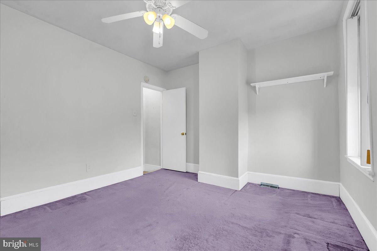 215 8th Street Brookhaven, PA 19015 - Photo 14 of 29 an empty room with a chandelier fan and windows