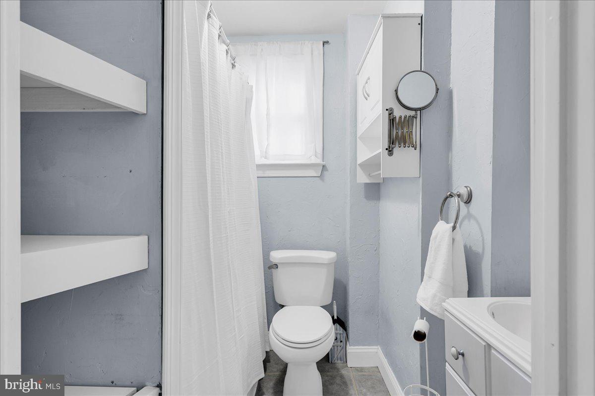 215 8th Street Brookhaven, PA 19015 - Photo 18 of 29 a white toilet sitting next to a bathroom sink