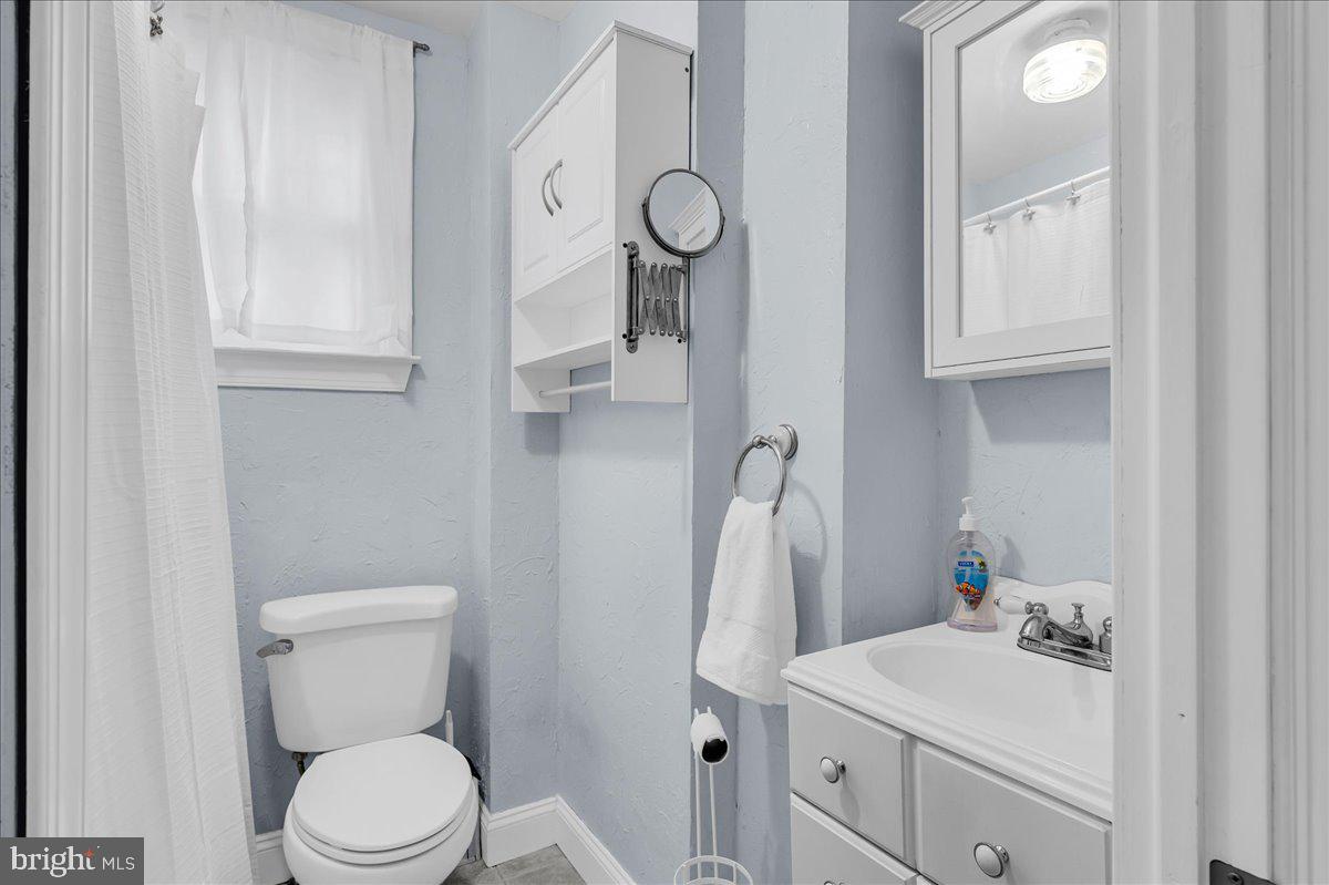 215 8th Street Brookhaven, PA 19015 - Photo 19 of 29 a bathroom with a toilet sink vanity and mirror