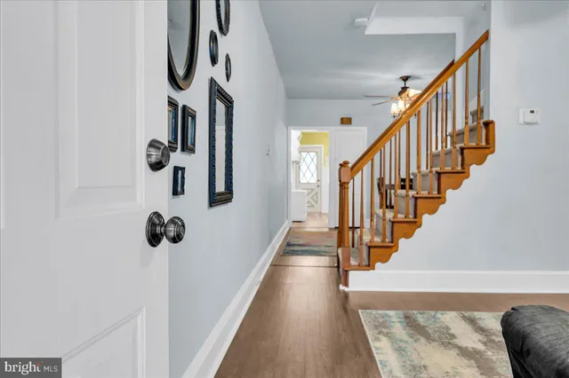 a view of staircase with lots of frames on wall and a window