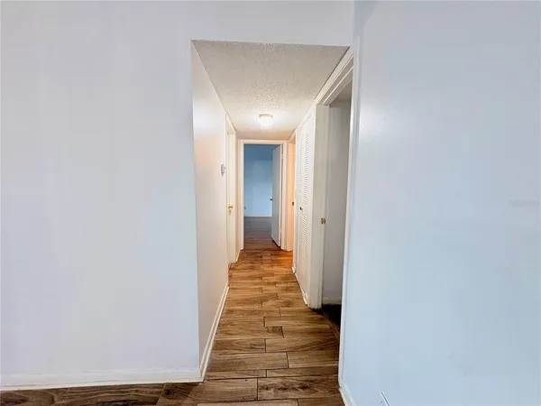 a view of a hallway with wooden floor