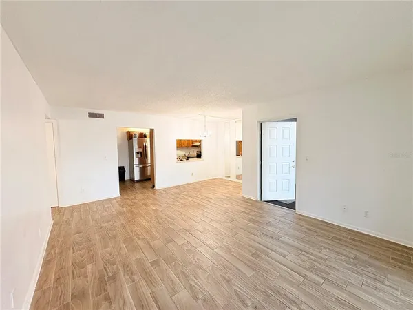 a view of empty room with wooden floor