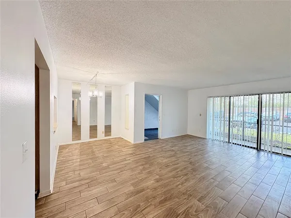 a view of a big room with wooden floor and windows