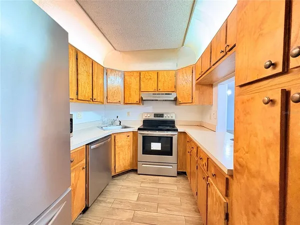 a kitchen with stainless steel appliances granite countertop a sink a stove and a refrigerator