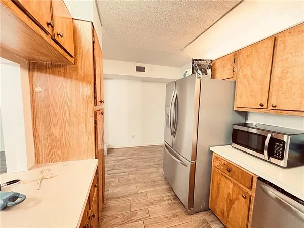 a kitchen with stainless steel appliances a refrigerator a stove and white cabinets
