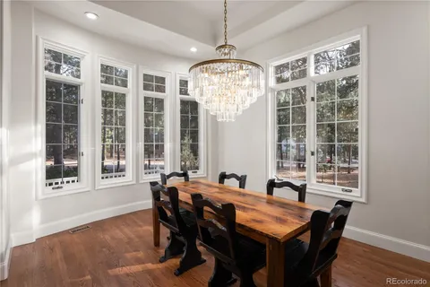 a view of a dining room with furniture large windows and wooden floor