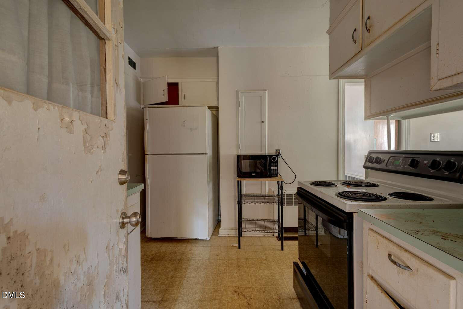 128 Nelson Street Durham, NC 27707 - Photo 12 of 23 a kitchen with a refrigerator and a stove top oven