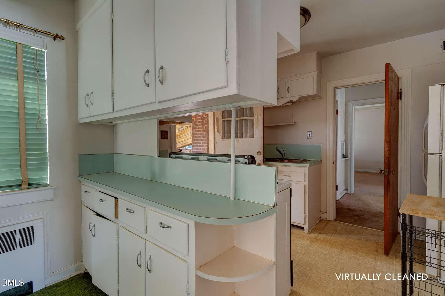 128 Nelson Street Durham, NC 27707 - Photo 10 of 23 a kitchen with white cabinets and refrigerator