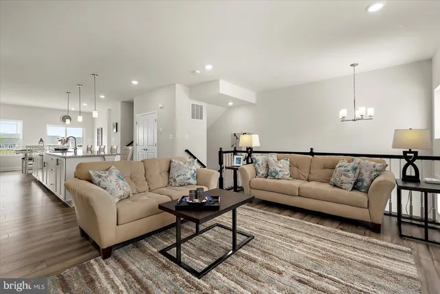 a large kitchen with kitchen island white cabinets and stainless steel appliances