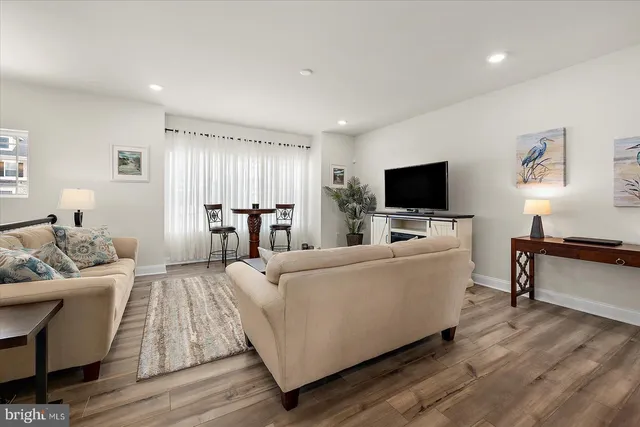 a kitchen with granite countertop white cabinets stainless steel appliances and wooden floor