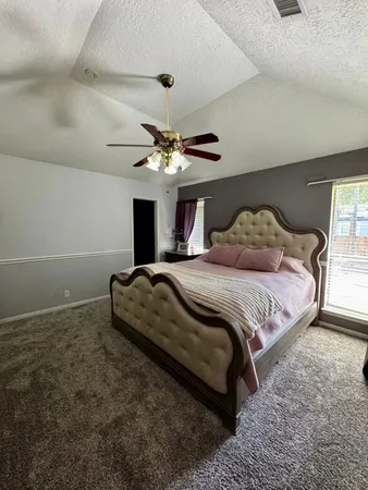 a bedroom with a large bed and a chandelier