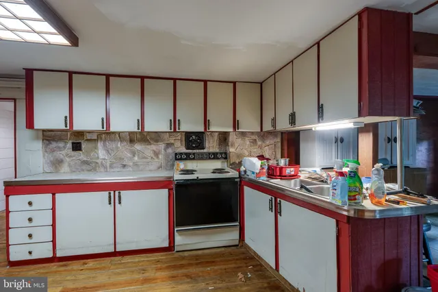 a kitchen with stainless steel appliances granite countertop a sink dishwasher stove and refrigerator with wooden floor