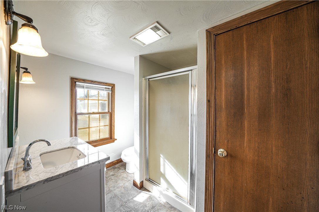 10258 Gilbert Road Newton Falls, OH 44444 - Photo 12 of 37 Bathroom with tile floors, vanity, walk in shower, and toilet