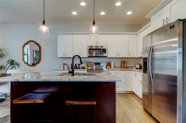 a kitchen with kitchen island a sink stainless steel appliances and cabinets