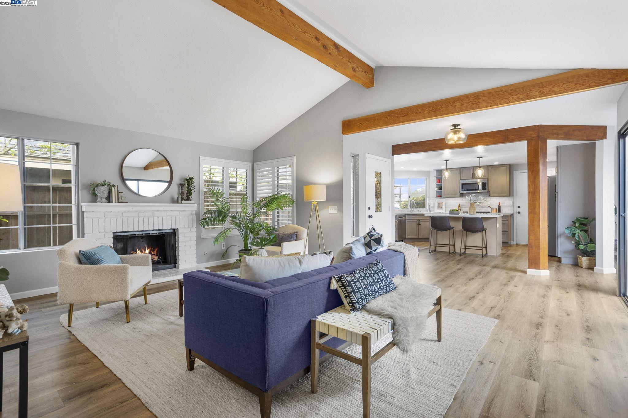 a living room with furniture a fireplace and a floor to ceiling window